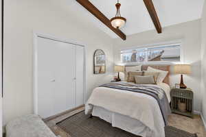Bedroom #4 featuring vaulted ceiling with beams, soft neutral carpeting and a chandelier. This bright bedroom is designed for rest and relaxation.