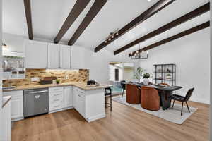 Cook and entertain in this bright kitchen featuring crisp white cabinetry and stainless steel finishes. The spacious peninsula doubles as a breakfast bar, making this a functional gathering spot.