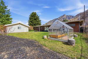 Rear exterior featuring sweeping views, a large covered patio, and a greenhouse.