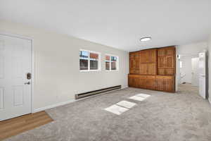 Flex-space featuring plenty of natural light, neutral carpeting, extra storage unit, baseboard heating, and a private entry. Possible ADU conversion, rental income, or a guest wing (buyer to verify city requirements).