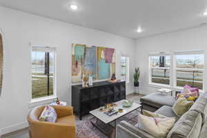 Living area with wood finished floors, plenty of natural light, and recessed lighting