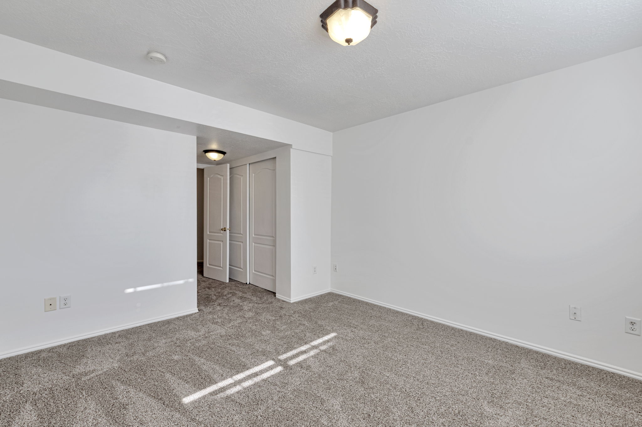 Carpeted spare room with baseboards and a textured ceiling