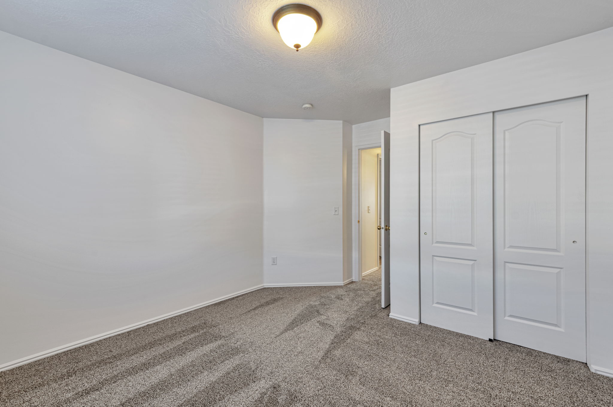 Unfurnished bedroom with carpet flooring, a closet, and a textured ceiling