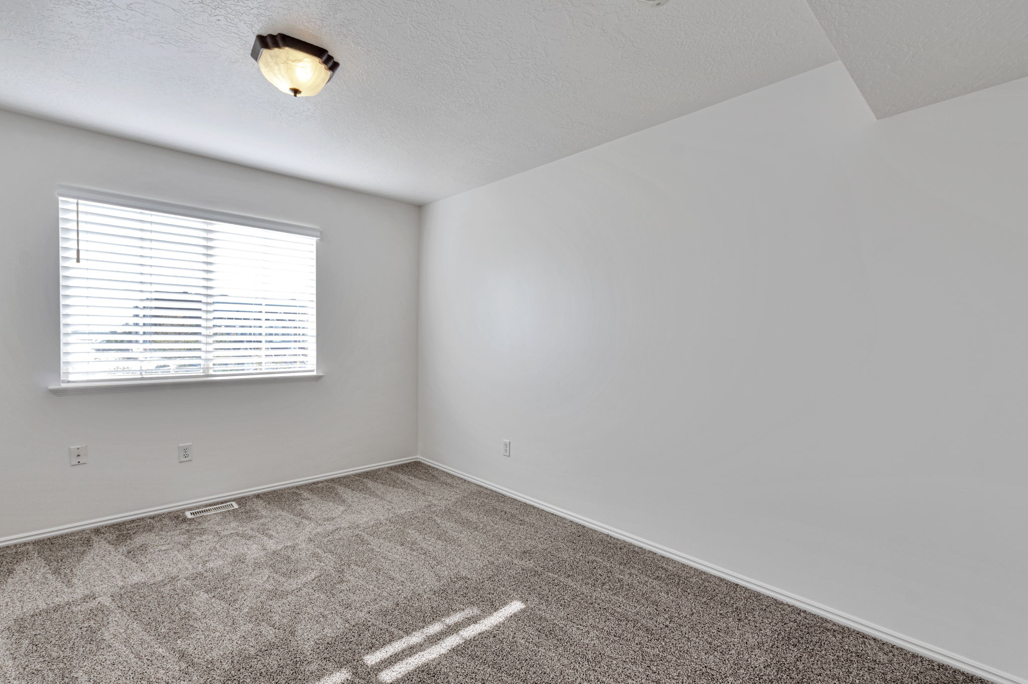 Carpeted empty room featuring a textured ceiling and baseboards