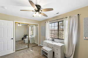 Carpeted bedroom with a closet and a ceiling fan