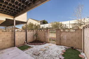 Fenced backyard featuring a patio and a gate