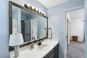 Bathroom with vanity, carpet flooring, and curtained shower