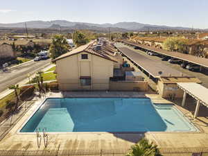 Community pool featuring a patio, a residential view, a mountain view, and a pergola
