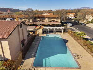 Community pool featuring a pergola, a mountain view, a patio area, and a residential view