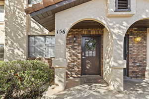 View of exterior entry with stucco siding and brick siding