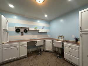 Office with built in desk, cabinets, carpet, and recessed lighting