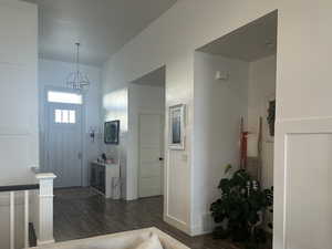 Entryway featuring 8 foot tall door, wood-style flooring, and custom wall molding