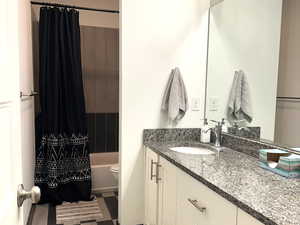 Full bath featuring double vanity, tile flooring, and shower/bathtub combination