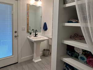 Bathroom with indoor/outdoor access featuring built-in storage and pedestal sink