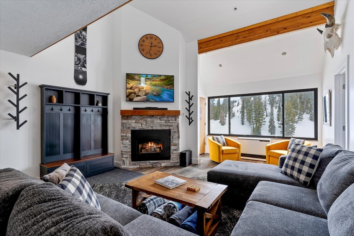 Living area featuring lofted ceiling, a fireplace, and wood finished floors
