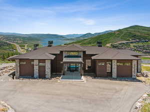 View of front of property with a mountain view, roof with shingles, an attached garage, concrete driveway, and brick siding