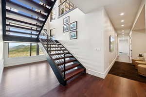 Stairs featuring wood finished floors, a high ceiling, and a mountain view