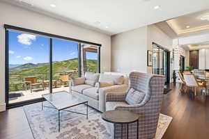 Living area featuring dark wood-type flooring, a mountain view, recessed lighting, and a raised ceiling