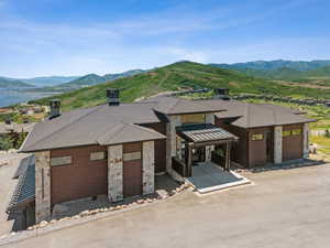 View of front facade featuring a mountain view, stone siding, and a chimney