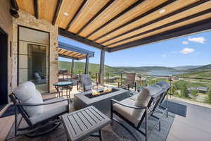 View of patio / terrace with a mountain view and an outdoor living space with a fire pit