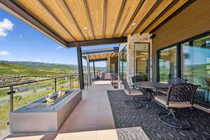 View of patio featuring an outdoor fire pit, outdoor dining area, and a mountain view