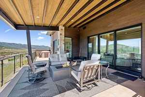 View of patio with a mountain view and an outdoor living space with a fire pit