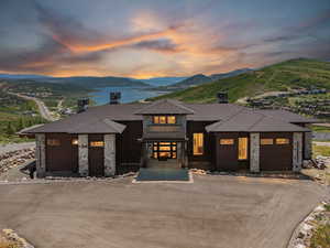 View of front of house with a mountain view, a shingled roof, a garage, and asphalt driveway