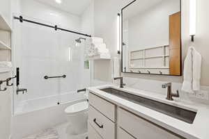 Full bathroom with double vanity, combined bath / shower with glass door, and recessed lighting