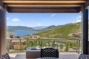 Balcony featuring a water and mountain view