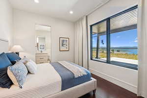 Bedroom featuring dark wood finished floors, a water view, and recessed lighting