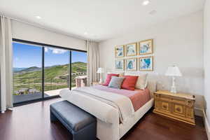 Bedroom with a mountain view, access to outside, dark wood-style flooring, and recessed lighting