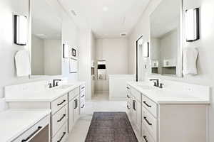Full bathroom with two vanities and light marble finish floors