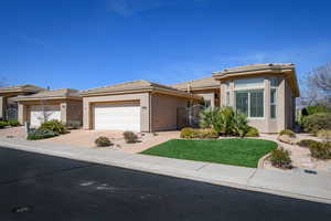 Prairie-style house featuring concrete driveway, stucco siding, an attached garage, a gate, and a tile roof