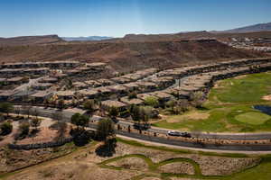 Aerial perspective of suburban area featuring a mountain backdrop and a local golf course