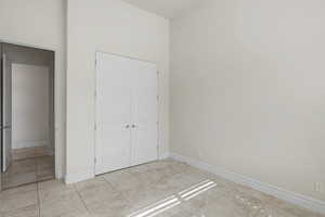 Unfurnished bedroom with a closet and a high ceiling