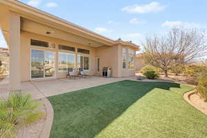 View of grassy yard featuring a patio