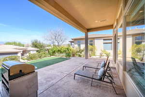 View of patio with a grill