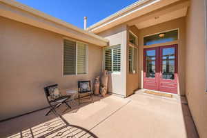 View of exterior entry featuring stucco siding, french doors, and a patio
