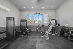 Gym with dark flooring and a mini split for heating / cooling