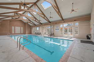 Indoor community pool featuring a skylight