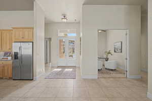 Entryway with a high ceiling and light tile patterned flooring