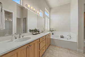 Bathroom featuring double vanity, a bath, and light tile patterned flooring