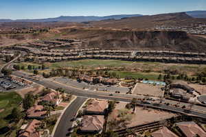 Aerial view of property and surrounding area with a mountain backdrop and nearby suburban area