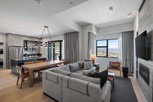 Living room with a fireplace, light wood-style floors, plenty of natural light, and recessed lighting