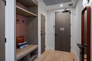 Mudroom featuring light wood-type flooring, recessed lighting, and arched walkways
