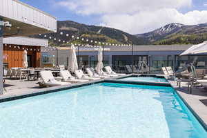 Community pool with a patio area, a mountain view, and a hot tub