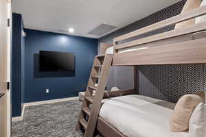Bedroom with dark colored carpet and baseboards