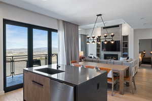 Kitchen with modern cabinets, light wood-style floors, a kitchen island with sink, a mountain view, and a fireplace