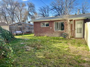 Unit 4367 View of home's back yard and exterior featuring secluded yard, lawn, brick and a central AC unit