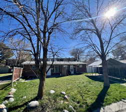 View of front facade with brick siding and a detached carport